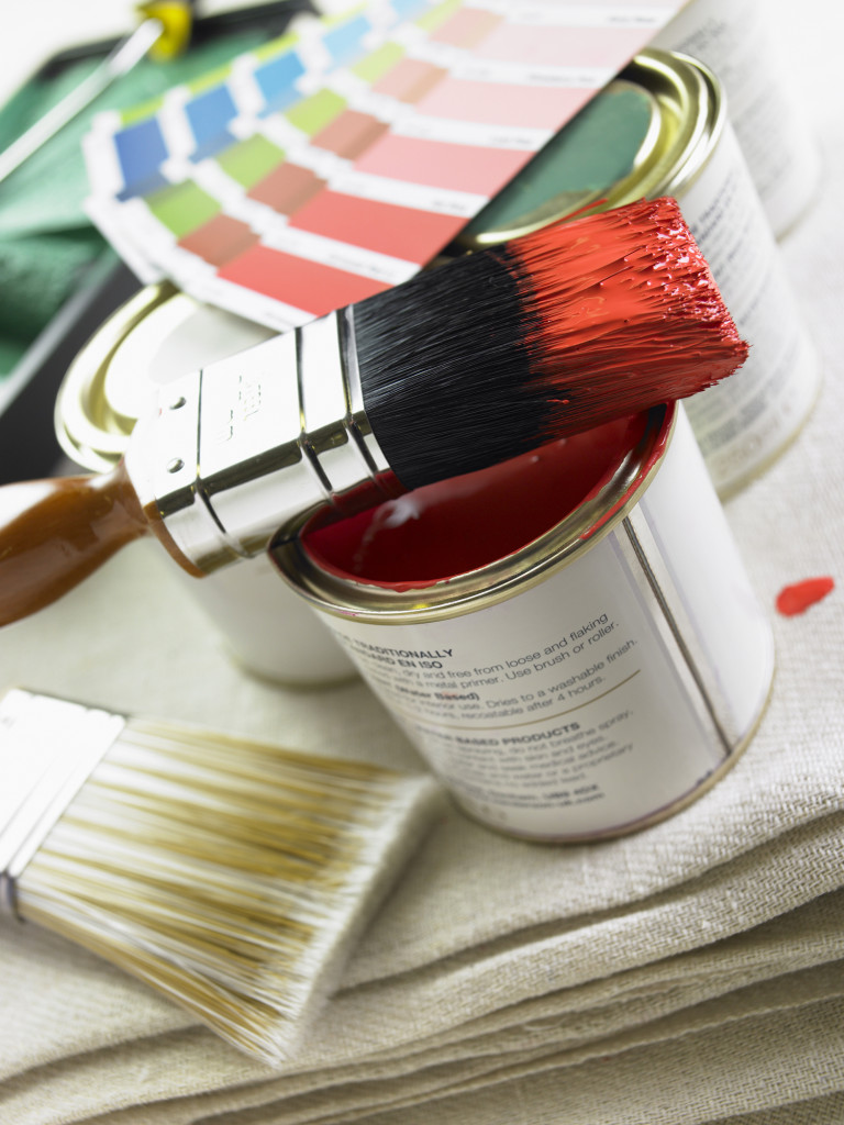 Stack Of Paint Brushes, Paint Tins And Color Wheels