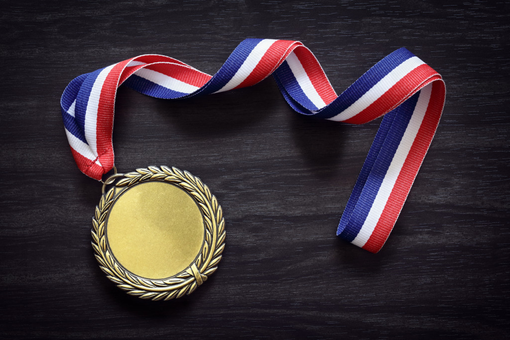 Gold medal on black wood background with blank face for text, concept for winning or success