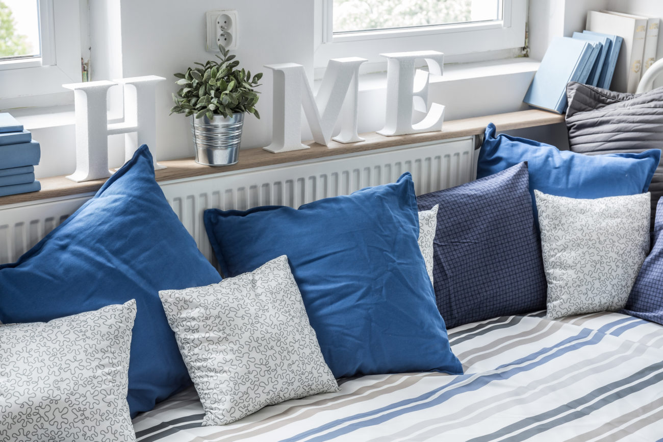 Cozy bed with lots of pillows in children bedroom