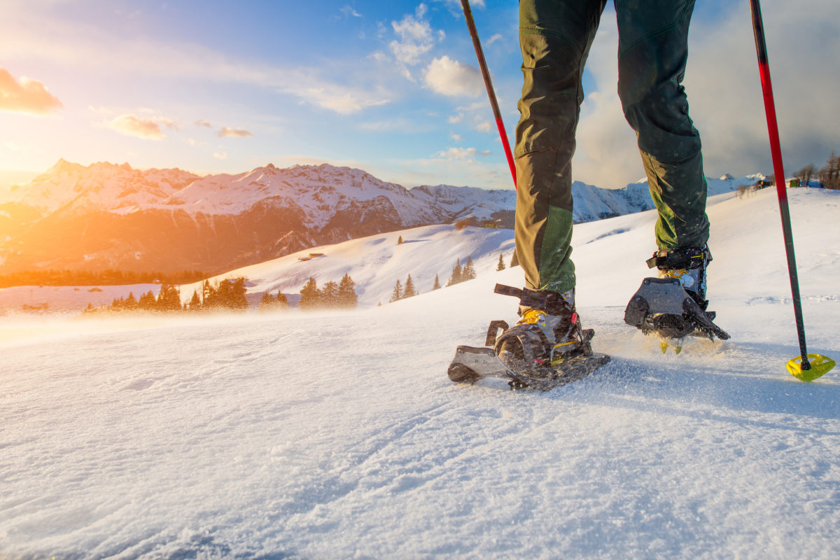 Detail of man walking with technical snowshoes in mountains