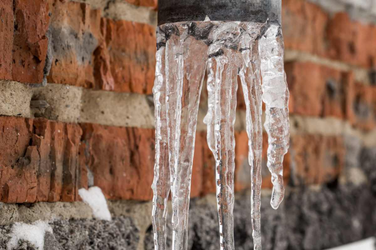 Natural icicles hanging on the pipe, the concept of winter