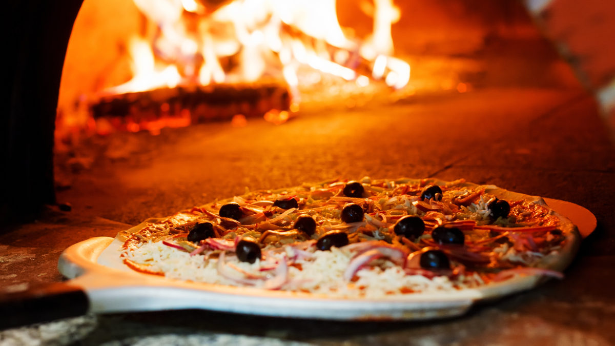 Pizza baking in a brick pizza oven.