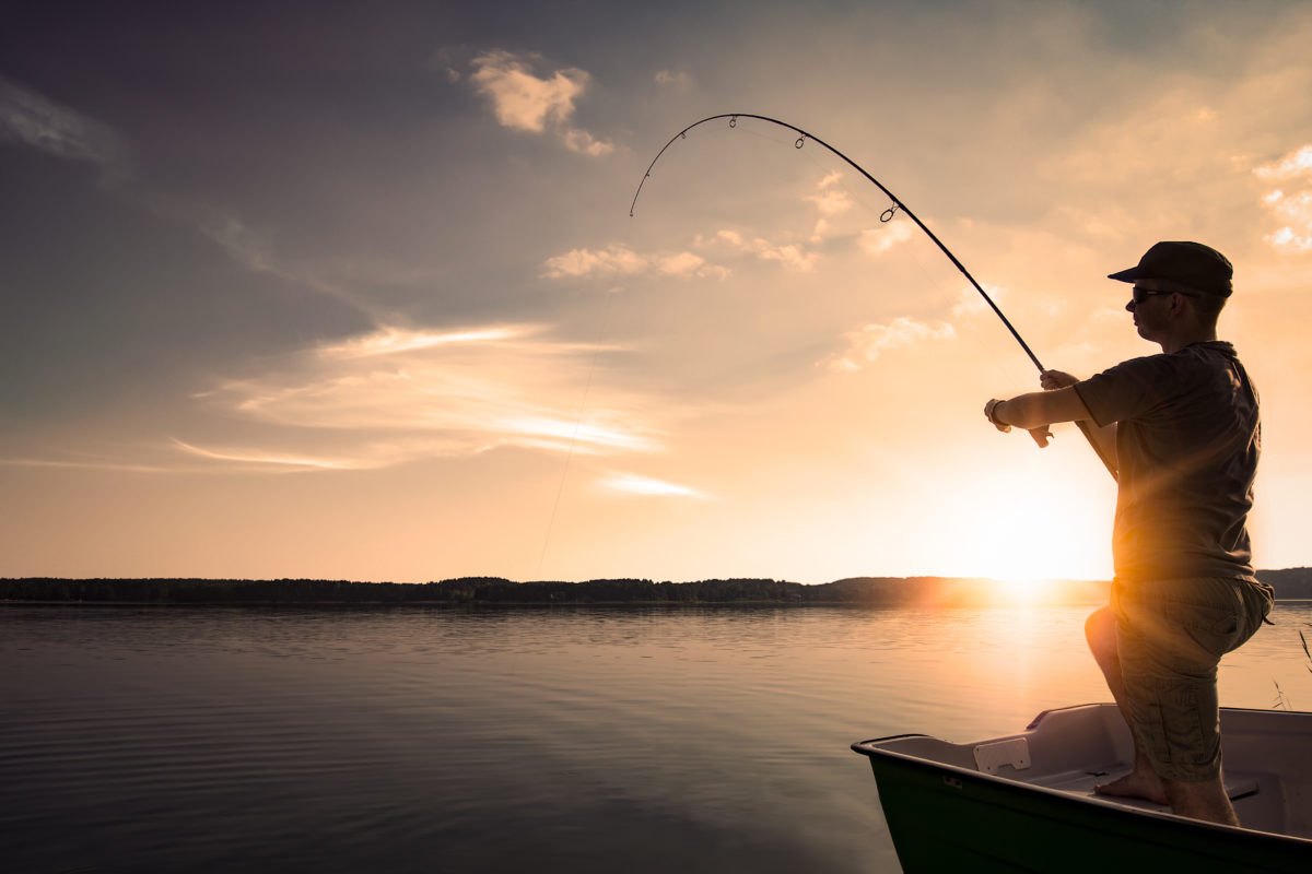 fishing rod lake fisherman men sport summer lure sunset water outdoor sunrise fish - stock image