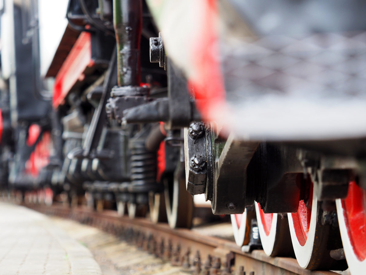 Old steam train wheels approaching, close-up, view from a railway. Black and red