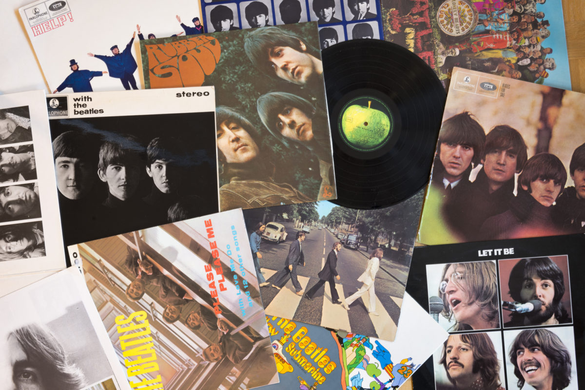 Gothenburg, Sweden - March 2, 2014: The Beatles musical pop/rock band from England. Vinyl record covers and one black vinyl record with a green apple on the label. Originals from the sixties, old and well used