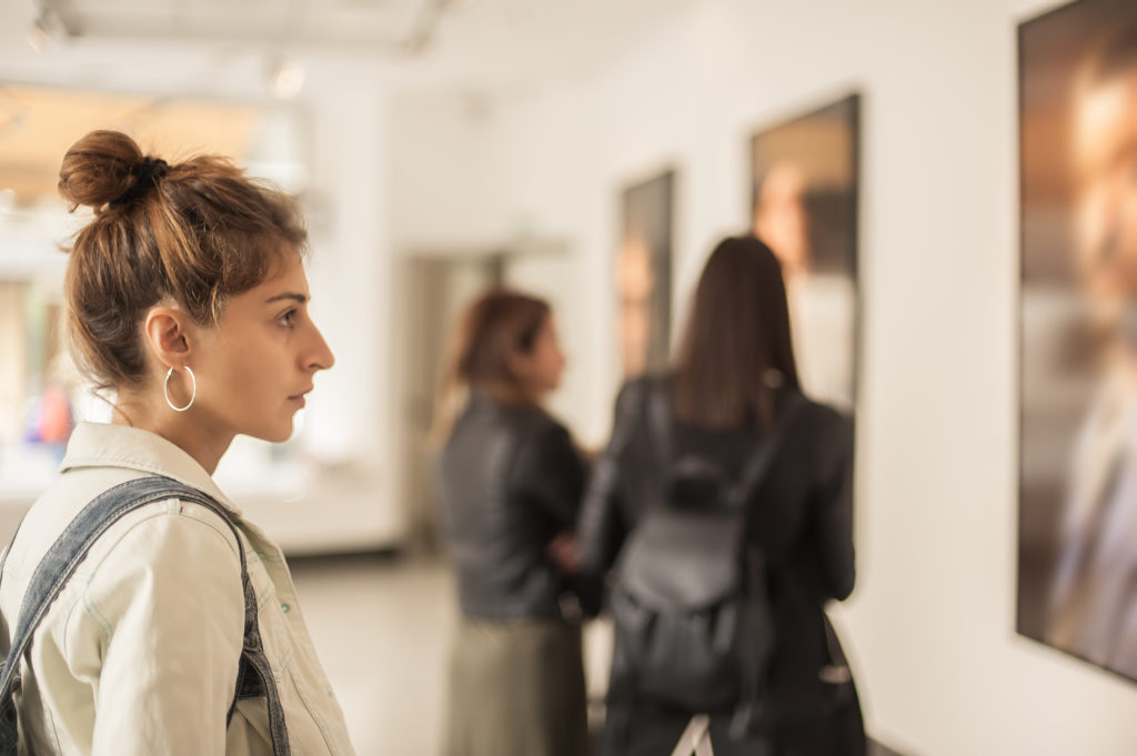 Group of woman looking at modern painting in art gallery. Abstract painting